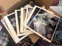 Photo showing a box of multiple photographic prints including a black and white portrait of a smiling woman