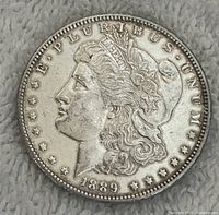 Obverse side of 1889 Morgan silver dollar showing Lady Liberty profile and date 1889.