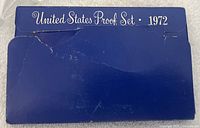 Blue folder with white title 'United States Proof Set 1972'. The folder shows wear and some creases.