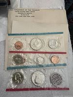 Image showing full set of coins sealed in original cellophane packaging inside a Treasury Dept envelope.