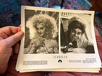 Hand holding multiple black-and-white movie still photos from Scrooged showing Carol Kane as Sugarplum Fairy and Bill Murray.