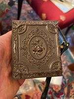 Front cover of gutta percha case showing ornate pear design and embossed detailing.