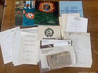 Wide view of assorted memorabilia and event programs related to Hollywood film industry from 1960s-1970s including award event brochures and printed invitations.