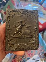 Front of the gutta percha daguerreotype case showing embossed cherub and stag design