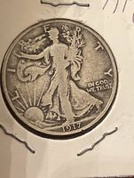 Obverse view of 1917 Walking Liberty Half Dollar showing Liberty walking towards left with sun on lower left and date 1917 at bottom.