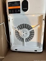 Photo showing the bottom of the white MORENTO air purifier with large circular air intake and digital display with brand name visible.