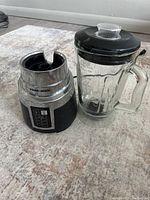 Mixer base and glass blending jar with lid shown from front angle, displaying control panel and jar features