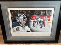 Framed color photographic print featuring Curtis Joseph in goalie gear on the ice, signed below the image with title 'The Last Line of Defense'.