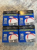 Four boxes of Maximum brand kitchen drawstring bags. Each box prominently displays '20' bags, 42L capacity, white color, with red drawstrings.