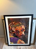 Framed art print of Kobe Bryant in a black frame with white matting, showing front of print with colorful painterly profile of Kobe Bryant wearing Lakers jersey.