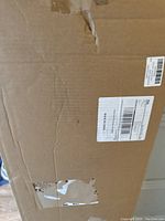 Closed cardboard box with shipping labels and moderate wear.