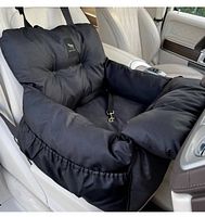 Photo of a grey padded dog car seat installed on a car front passenger seat. Shows cushioned sides, attached safety leash, and overall condition.