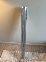 Full length view of the rolled PVC table mat standing vertically with light reflecting off its transparent surface.