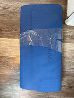 Folded blue Cambivo yoga mat with diamond-patterned texture, wrapped in clear plastic.