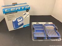 Photo showing the Certified air compressor box alongside the Mastercraft drill bit set in original packaging with multiple drill bits.