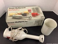 Braun Multipractic hand blender with power cord, mixing beaker, and original box visible in image