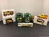 Photo showing the full lot including 1928 Chevrolet Pennzoil truck, two John Deere hanging ornaments in boxes, Princess Auto truck, Shell Motor oil truck and ProPoint transport truck.