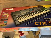 Box front displaying Casio CTK-558 model, features 100 Song Bank tones and MIDI capability, with an image of the keyboard.