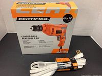 Boxed Certified corded drill and bundled white 3 meter extension cord.