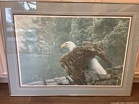 Framed full artwork showing the bald eagle perched on log with forest background and double mat framing