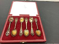 Full view of the 6 spoons in original red velvet-lined box with hinged lid.