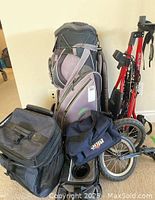 Image of lot contents showing gray EOS Strada golf bag, red BagBoy 3-wheel push cart, and three cooler bags including Labatt Blue cooler bag.