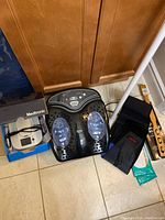 Foot massager on floor with Medtronic My CareLink monitor box next to it, leaning against cabinet doors, showcasing electronic health device and foot care item