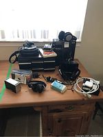 Wide view of all items on table including headphones, boxed cassettes, Panasonic CD player, microphone, cables, and carrying bag.