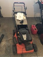 Front three-quarter view of mower showing deck, handle and grass catcher attached