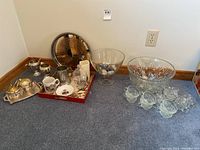 Photo showing the full assortment of serveware items including trays, mugs, and bowls arranged on floor near wall
