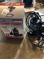 Superior Pump sump pump with original packaging on concrete floor showing front view of box and pump.