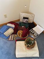 Overview of the table linens including folded cloth napkins in blue, burgundy, green, beige, and striped patterns, placemats, and three sets of napkin rings including champagne glass and diamond ring shapes.