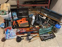 Overall lot arranged on floor showing tools, painting supplies, and hand tools