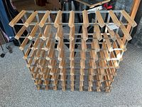 Front and side view of wine rack showing wood slat construction with metal rods, designed for 72 bottle capacity.