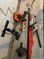 Craftsman 18 electric hedge trimmer and yard equipment including orange flag and manual pruner on beige carpet.