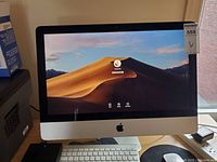Front view of iMac powered on showing login screen