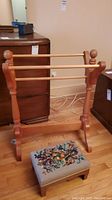 Wooden blanket rack and footstool together, showing rack's structure and footstool's needlepoint top