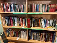 Front view of two wooden bookshelves filled with various books from cookbooks, classic literature, poetry, history and travel guides.