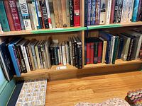 Two shelves filled with books showing titles and spines, variety of genres including history and photography