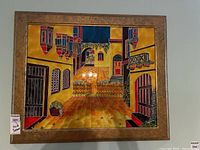 Front view of the framed artwork showing the street scene in vivid yellows and reds with signature visible.