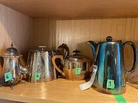 Group shot showing all four pieces: coffee pot, teapot, sugar bowl, creamer on wooden shelf