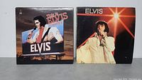 Front covers of 'This is Elvis Country' and 'Elvis' LP albums showing Elvis Presley in performance outfits