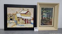 Lot of two framed paintings: one house scene in snow with black frame and one forest scene signed by Mary Anderson with a cream frame.