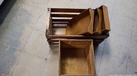 Wooden crate with three stacked wooden trays inside and wooden box beside them