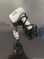 Photo of ConAir 1600 travel hair dryer with cord and plug powered off showing side logo and folded handle.