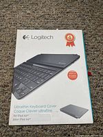 Front view of Logitech Ultrathin Keyboard Cover box for iPad Air showing branding and product image.