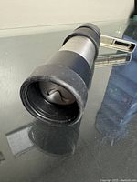 Close-up of the cookie press open end revealing an interchangeable design disc inside, for creating shaped cookies.