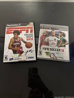 Front covers of two sports video games: ESPN College Hoops 2K5 for PlayStation 2 and FIFA Soccer 12 for PlayStation 3.