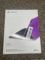 Box of Logitech Type-S keyboard case for Samsung Galaxy Tab A 9.7 in purple, showing front packaging with product image and model details.