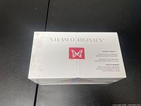 Front view of the sealed white box with butterfly logo and Steam Originals branding.